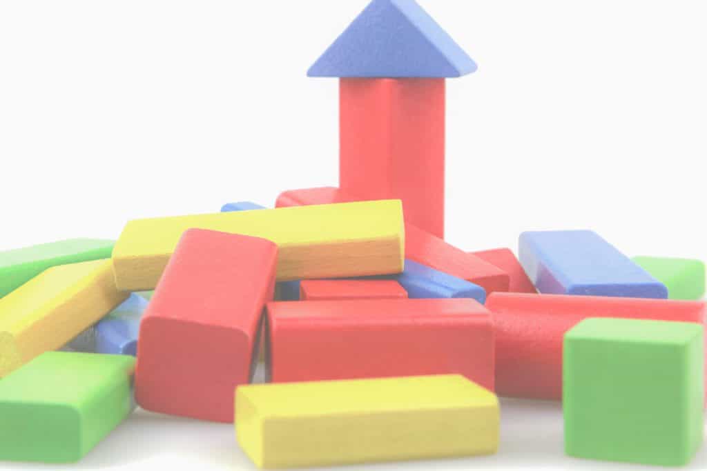 colored wood blocks with one small tower symbolizing celebrating small victories one block at a time